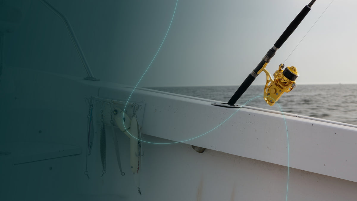Gold Visser PierMaster spinning reel mounted on a fishing rod beside a white boat